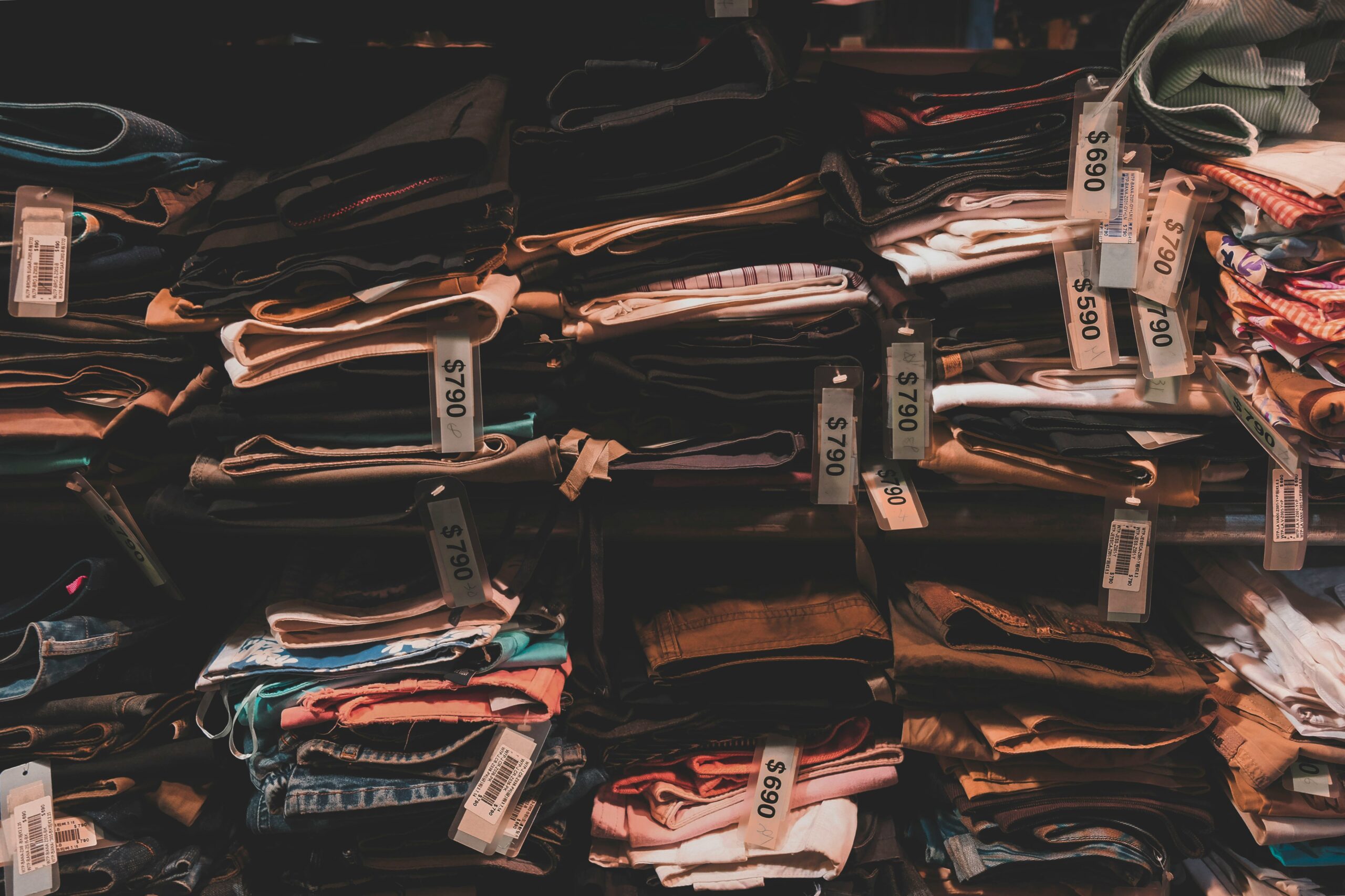 A messy closet filled with clothes hanging haphazardly