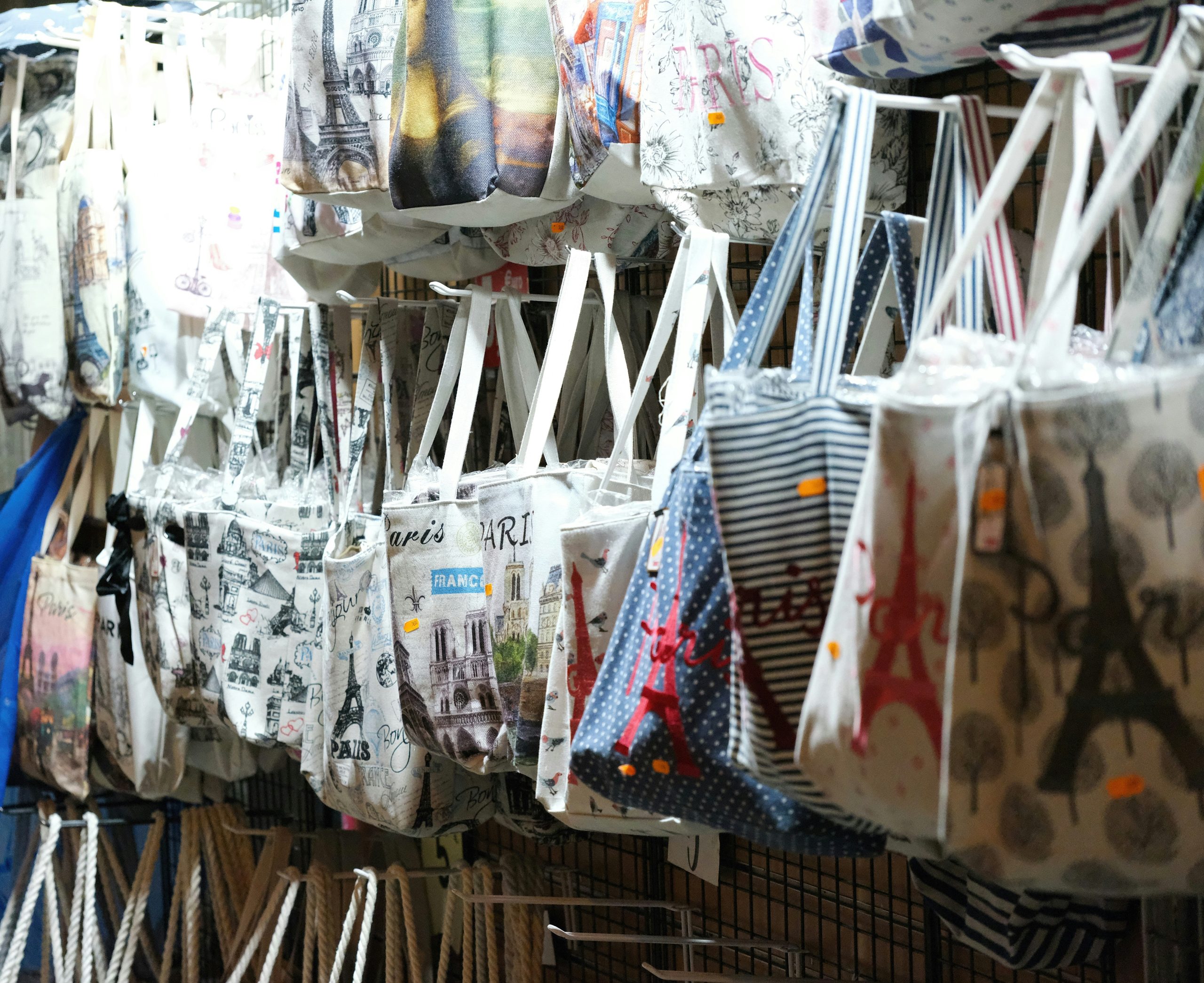 A woman standing overwhelmed amid stacks of clothing racks inside Bloomingdale's store