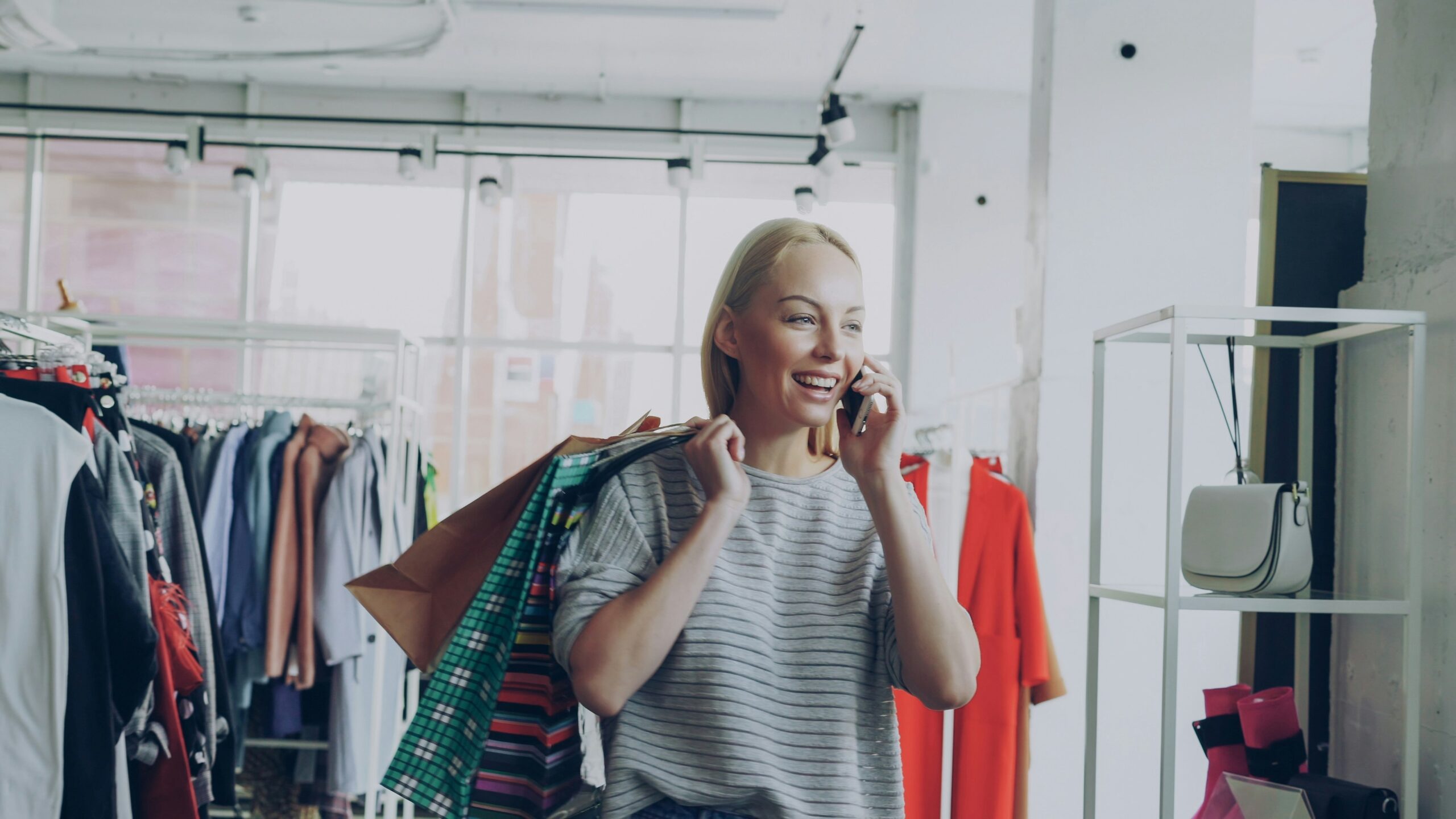 Woman smiling while choosing clothes from a colorful wardrobe