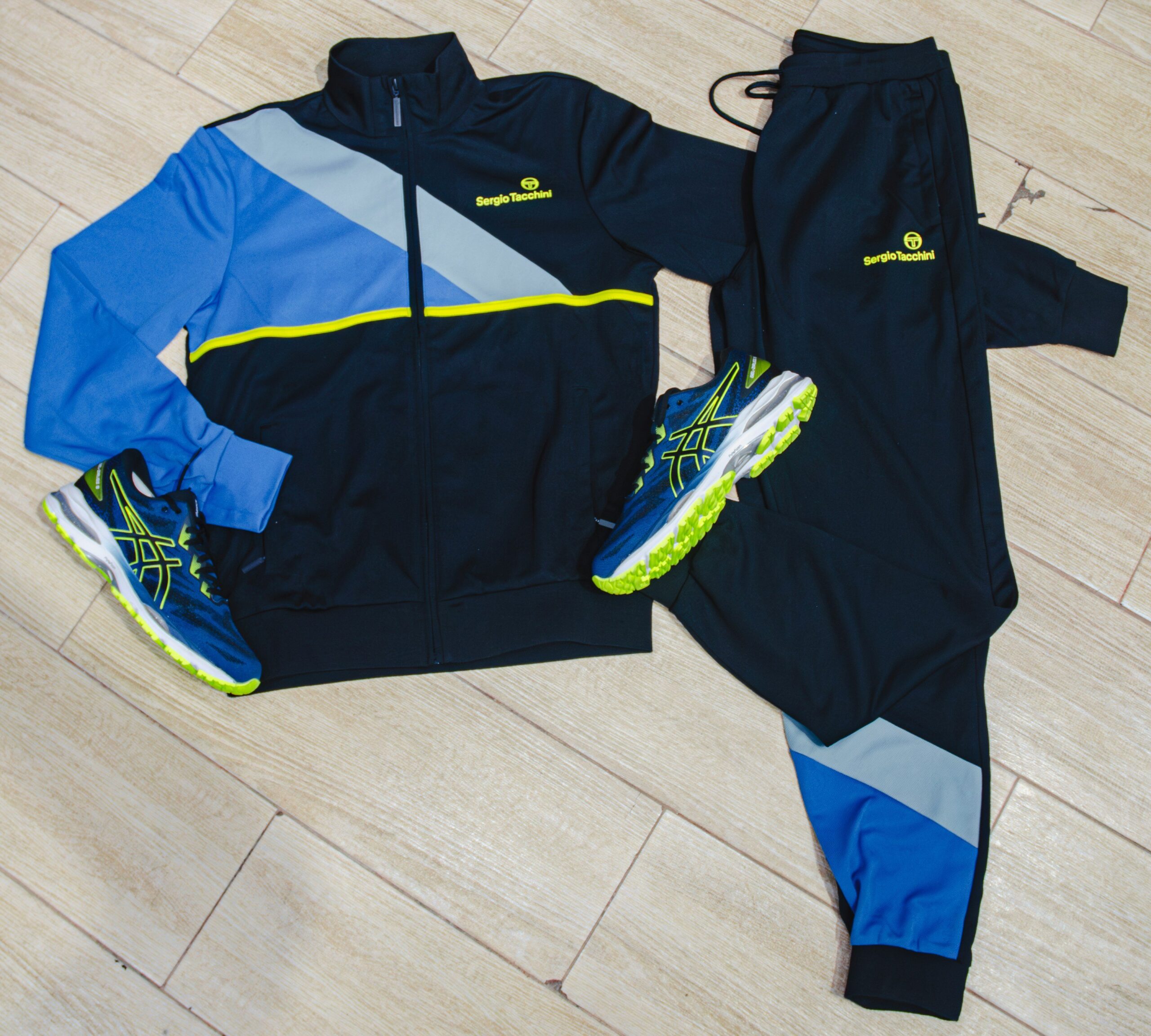 Sporty accessories including a water bottle, sunglasses, and sleek crossbody bag styled alongside activewear.