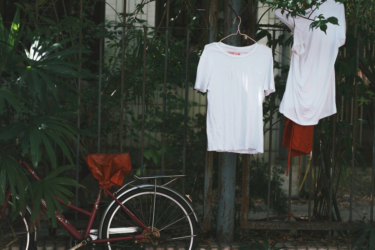 A model wearing green activewear standing against a backdrop of plants