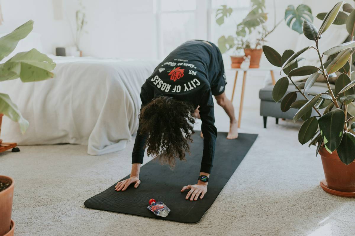 Three favorite yoga pieces laid out on a wooden floor: leggings, bra, and tee.
