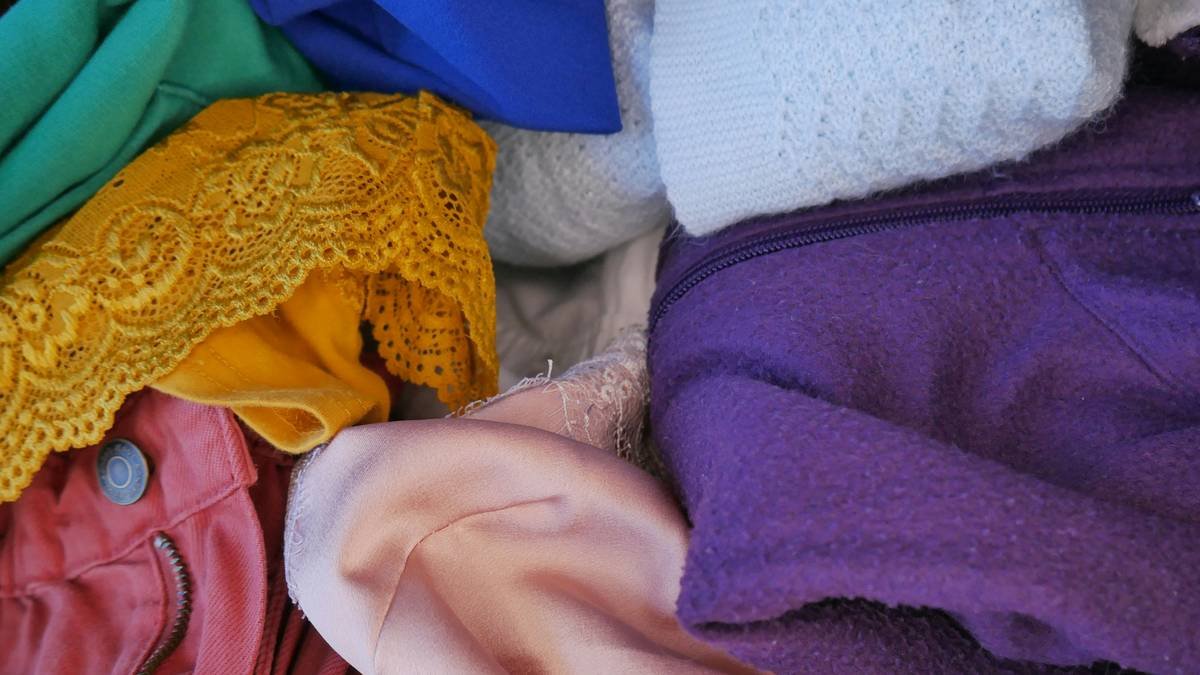 Infographic showing 5 laundry color groups: whites, lights, brights, darks, reds/oranges—with Bloomingdale's garment examples in each category