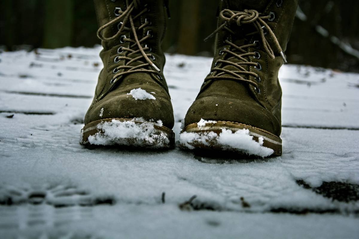 Infographic comparing waterproof vs water-resistant boots, insulation levels, and sole traction ratings for winter conditions